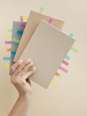 pessoa-segurando-livros-com-adesivos-coloridos-de-lembrete